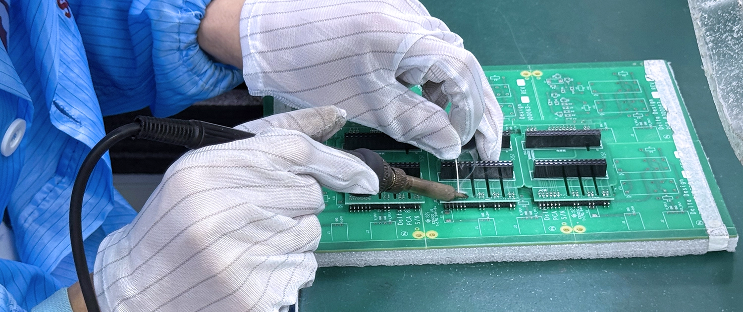 Technicians soldering a double-layer circuit board